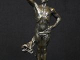 bronze statue of a man holding a bird on a black background
