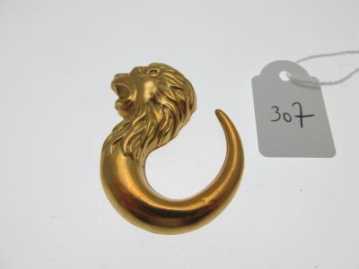 une image représentant une tête de lion en or surmontant un croissant en or