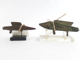 deux petits avions en bois exposés sur une surface blanche