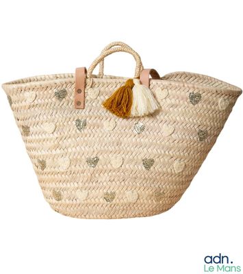panier tressé avec des pompons et des anses en cuir sur fond blanc