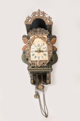 une horloge accrochée au mur, entourée d'une chaîne