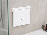 une porte de douche en verre dans une salle de bains équipée d'un distributeur de savon fixé au mur