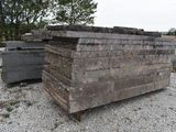 a pile of wood sitting on top of a gravel field