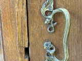 a close up of a metal handle on a wooden cabinet