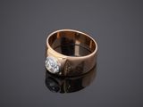 a close up of a gold and diamond ring on a reflective surface