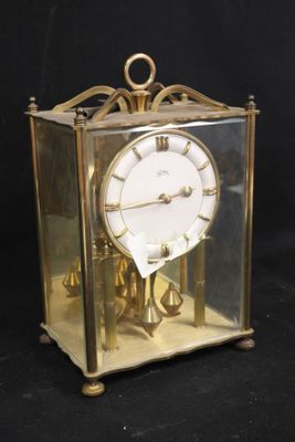 une horloge en or placée dans une boîte en verre