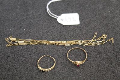two gold rings and a pair of gold rings on a black surface