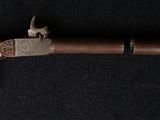 a close up of a gun with a wooden handle on a black background
