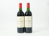 deux bouteilles de vin rouge posées l'une à côté de l'autre sur une surface blanche