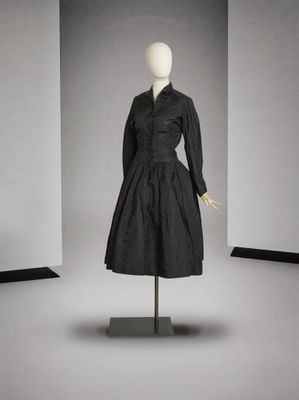 une photo d'une robe noire posée sur un mannequin dans une pièce