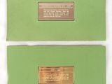 two pieces of green paper with a gold plaque on it