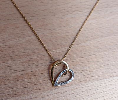 un collier en or orné d'un cœur en diamant