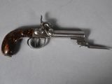 an antique silver plated revolver with a wooden handle