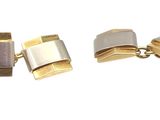 trois boutons de manchette en or et en argent sur fond blanc