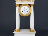a white and gold clock sitting on top of a table