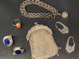 un assortiment de bijoux en argent, notamment des bagues, des bracelets et un sac à main