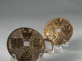 pair of chinese coins on acrylic stand on white surface