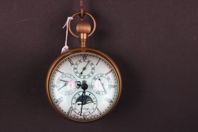 une montre de poche accrochée au mur avec un ruban rose