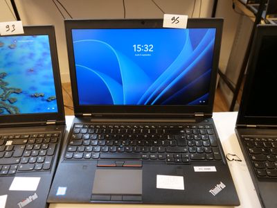 three laptops are sitting on a table with price tags on them