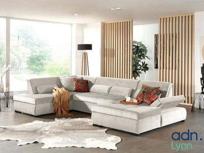 un salon avec un grand canapé modulable et un tapis