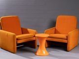 une paire de chaises orange et une petite table dans une pièce