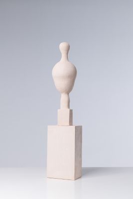 une sculpture blanche posée sur un socle blanc