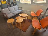 une photo d'un salon avec un canapé, des fauteuils et des tables
