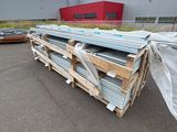 a pile of metal sheets on a pallet in front of a building