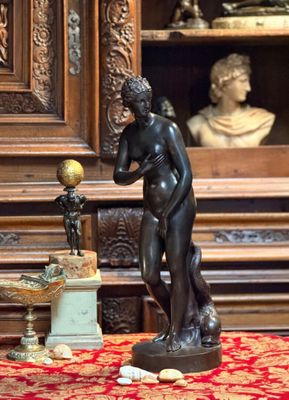 une statue représentant un homme tenant un globe terrestre, à côté d'une statue représentant un garçon