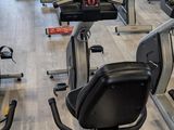 rows of stationary exercise bikes in a gym with a wooden floor