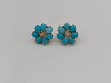 une paire de boucles d'oreilles en turquoise posées sur un fond blanc