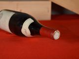 a bottle of wine sitting on a red table
