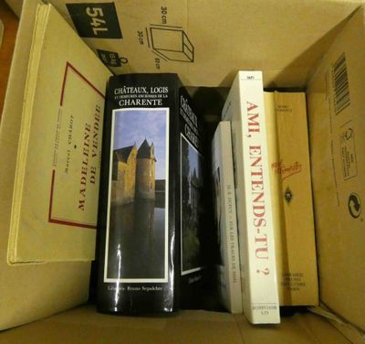 des livres dans une boîte en carton posée sur une table, à côté d'autres livres