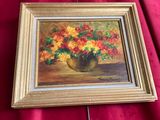 une peinture à l'huile représentant des fleurs dans un vase posé sur un tissu rouge