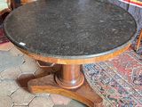 a table with a black marble top on a rug