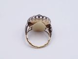 a close up of a gold ring with diamonds on a white surface