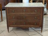 a marble top chest of drawers in the middle of a room