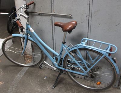 a blue bicycle parked next to a wall in a parking garage