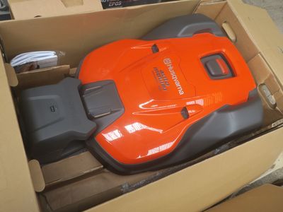 un aspirateur orange et noir dans une boîte en carton