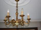 a gold chandelier with five lights hanging from the ceiling