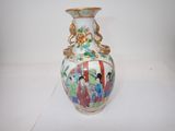 a vase with a painting on it sitting on a table