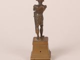 an antique bronze figurine of a man holding a book on a pedestal