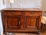 a wooden cabinet with two drawers and a lamp on top of it