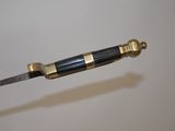 a knife with a gold handle on a white surface
