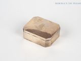 a silver box sitting on a white surface with a white background