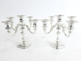 trois chandeliers en argent sur fond blanc, avec un fond blanc