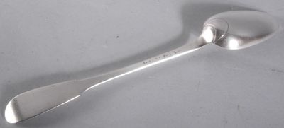 an antique silver spoon with a spoon handle on a white surface