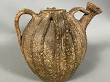 a brown vase that is sitting on a white surface