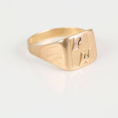 a close up of a gold signet ring on a white surface