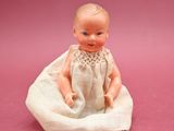 a small figurine of a baby sitting on a blanket
